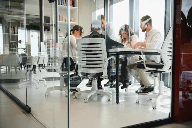 Um grupo de empresários parceiros durante uma reunião de equipe no escritório moderno. Conceito de trabalho em equipe