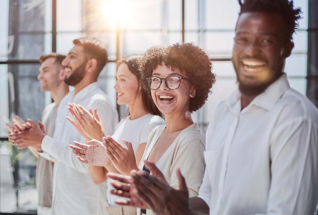 Um grupo de empresários sentados em fila e aplaudindo