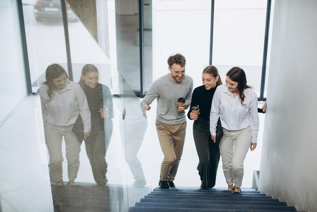 Um grupo de empresários subindo as escadas do edifício moderno conversando