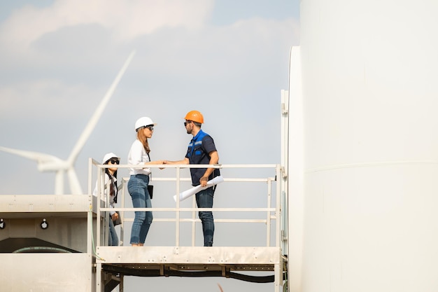 Um grupo de engenheiros e arquitetos trabalha no piso da base de uma turbina eólica