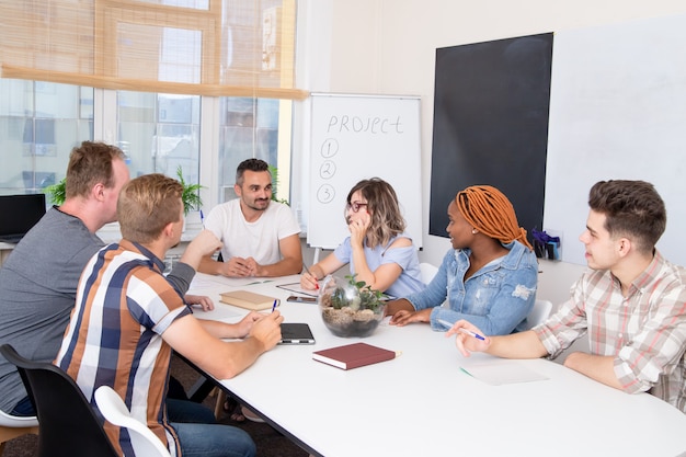 Um grupo de estudantes em um treinamento de negócios ouve o orador.