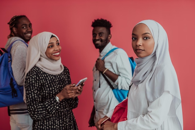 Um grupo de estudantes muçulmanos africanos com mochilas posando em um fundo rosa. o conceito de educação escolar. Foto de alta qualidade