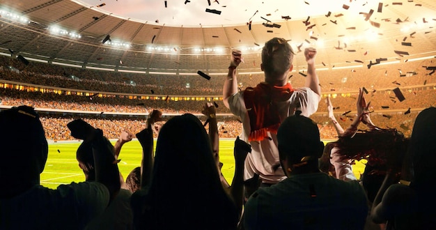 Um grupo de fãs aplaudindo assistem a um campeonato esportivo no estádio sua equipe ganha e todos estão celebrando este evento as pessoas estão vestidas com roupas casuais