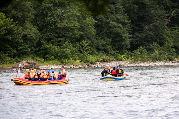 Um grupo de homens e mulheres pratica rafting no rio, esporte radical e divertido