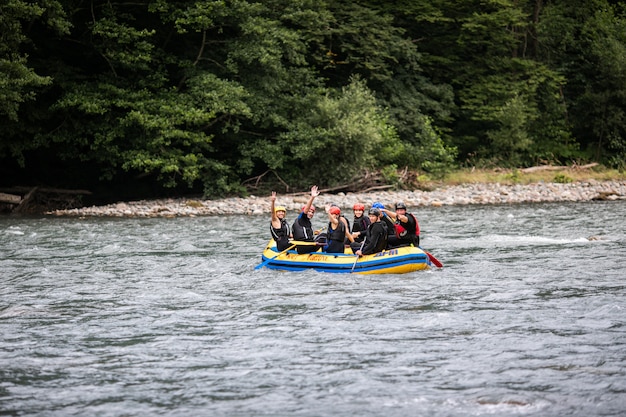 Um grupo de homens e mulheres pratica rafting no rio, esporte radical e divertido