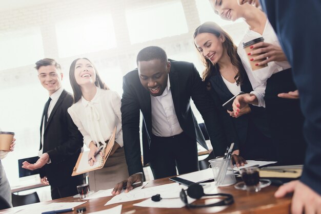 Um grupo de jovens detém de brainstorming no escritório.