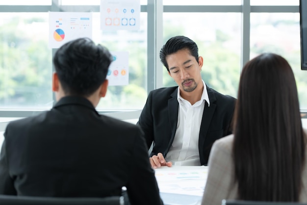 Um grupo de jovens empresários asiáticos Top Management está se reunindo para rever o estoque