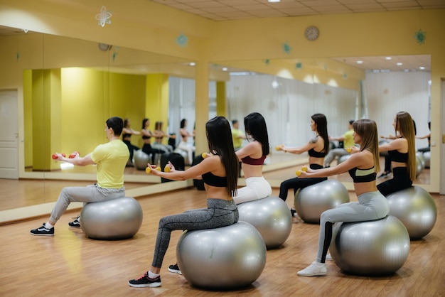 Um grupo de jovens envolvidas em fitness nas bolas. estilo de vida saudável.