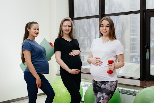 Um grupo de jovens grávidas pratica ioga e socializa dentro de casa. estilo de vida saudável