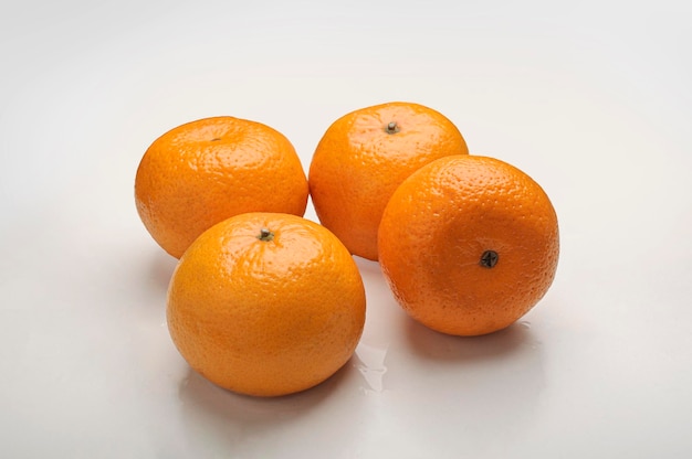 Foto um grupo de laranjas em uma superfície branca