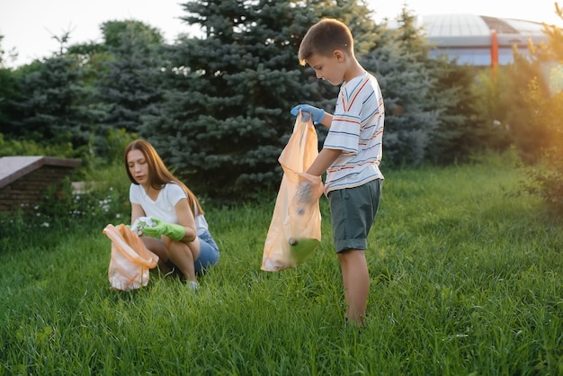 Um grupo de meninas com filhos ao pôr do sol está envolvido na coleta de lixo no parque. cuidado com o meio ambiente, reciclagem.