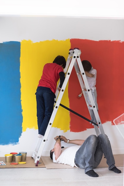 um grupo de meninos ajuda a pintar uma parede na nova casa