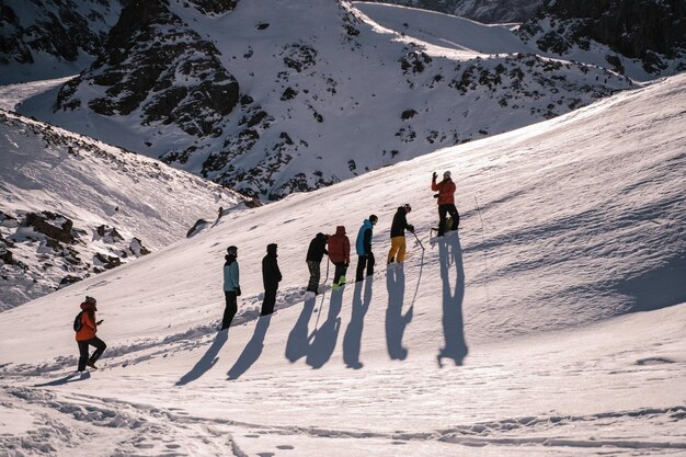 Um grupo de pessoas é treinado em uma encosta nevada nas montanhas