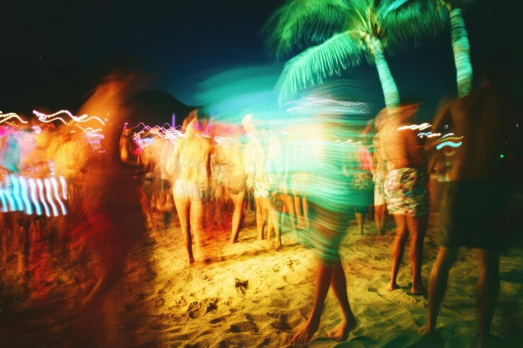 Foto um grupo de pessoas está dançando em uma praia à noite imagem generativa ai