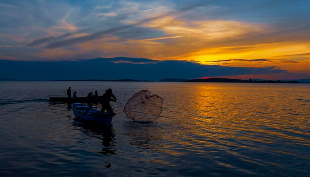 um grupo de pessoas está pescando na água com uma rede de pesca