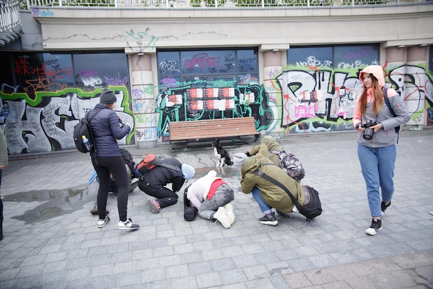 Um grupo de pessoas está reunido em torno de uma parede grafitada.