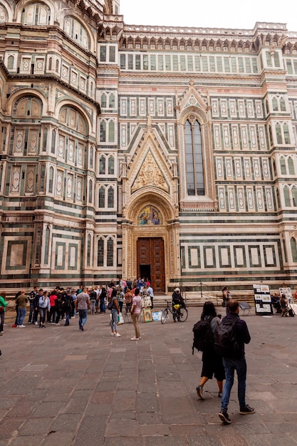 Um grupo de pessoas fica em frente a um grande prédio que diz "duomo".