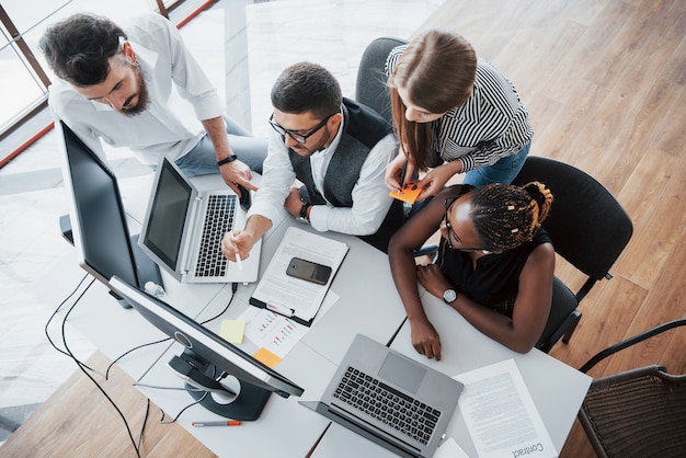 Um grupo de pessoas multinacionais ocupadas trabalhando no escritório. vista de altura