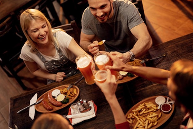 um grupo de pessoas sentadas em uma mesa com comida e bebidas