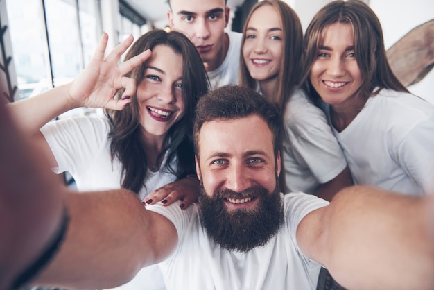 Um grupo de pessoas tira uma foto de selfie em um café. Os melhores amigos reunidos