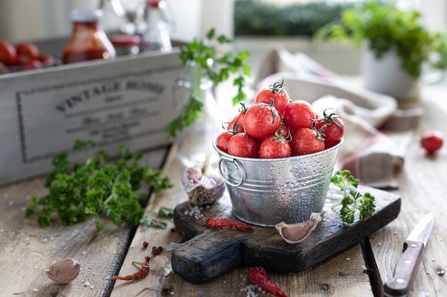 Um grupo de tomates cereja vermelhos maduros como ingrediente do molho. Em uma mesa de madeira