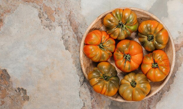 Um grupo de tomates grandes Costoluto em um espaço de placa de madeira para texto