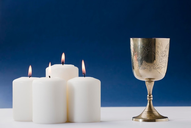 Um grupo de velas está ao lado de uma taça de prata com a palavra "fogo" nela.