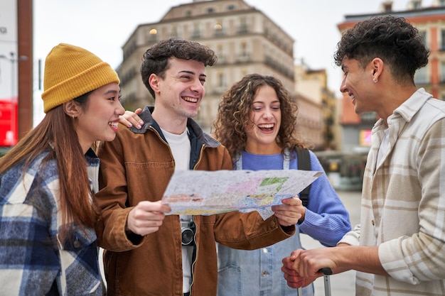 Foto um grupo diversificado de amigos rindo e planejando sua aventura turística em madri com um mapa da cidade