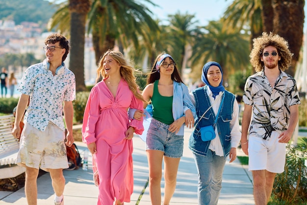Um grupo diversificado de turistas vestidos com trajes de verão passeia pela cidade turística com amplas