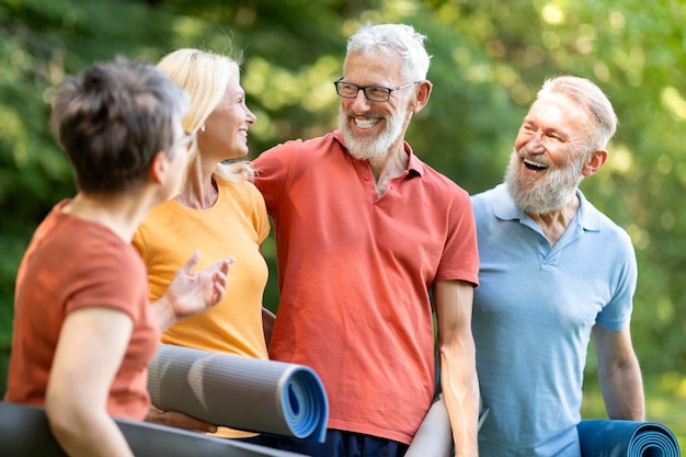 Um grupo feliz de idosos a conversar antes de um treino desportivo ao ar livre