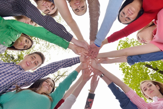 Foto um grupo feliz e sorridente de jovens amigos ficando juntos ao ar livre no parque