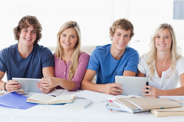 Um grupo sorridente de estudantes olhando a câmera