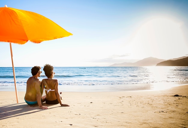 Foto um guarda-chuva laranja na praia .