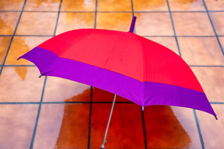 Foto um guarda-chuva vermelho deitado no chão ensopado em um dia frio de inverno