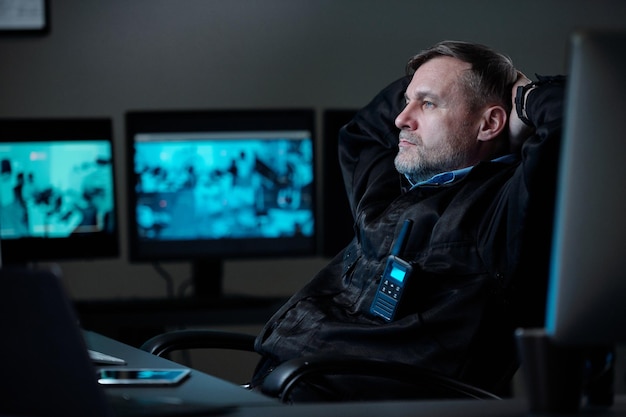 Um guarda descansado a olhar para o ecrã do computador.
