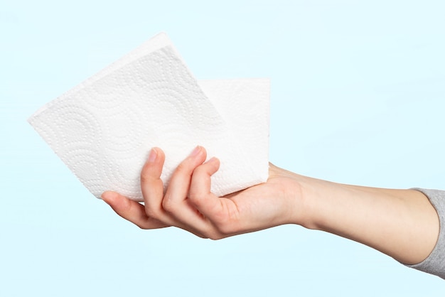 Foto um guardanapo de papel ou toalha de papel na mão de uma mulher. conceito de higiene