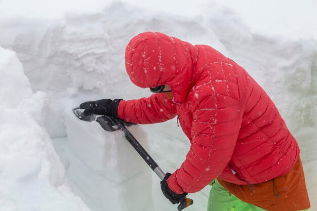 Um guia de montanha com uma pá verifica a cobertura de neve em busca de perigo de avalanche nas montanhas uma adrenalina aventuras de freeride de inverno ao ar livre