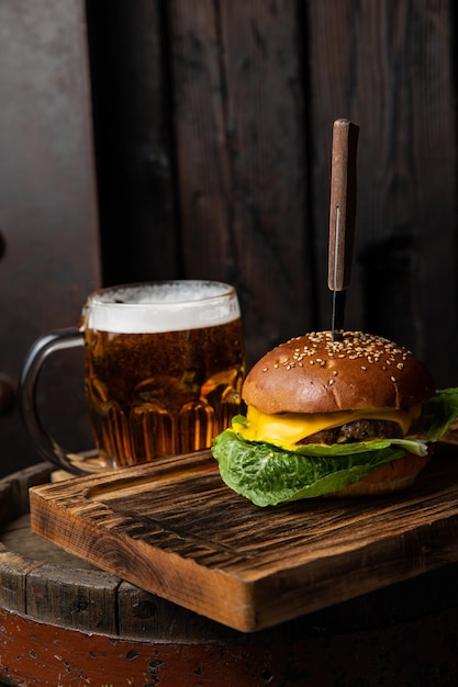 Um hambúrguer com uma caneca de cerveja na mesa