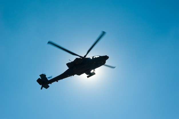 Um helicóptero no céu com o sol atrás dele