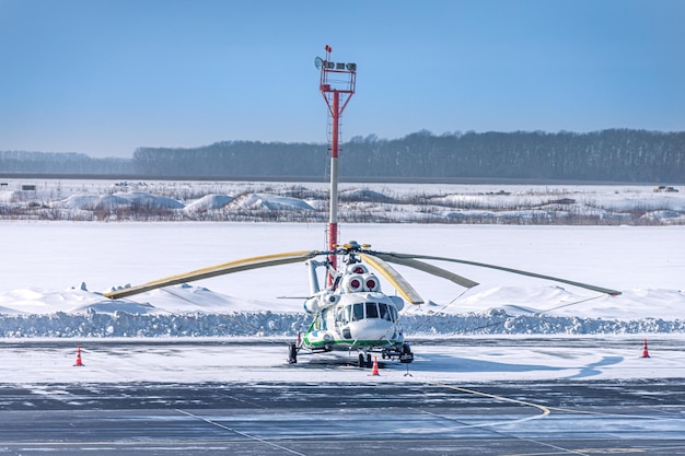 Um helicóptero preservado está no estacionamento do aeroporto no inverno