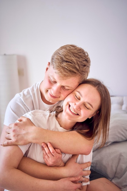 um homem abraça sua esposa por trás cara a cara