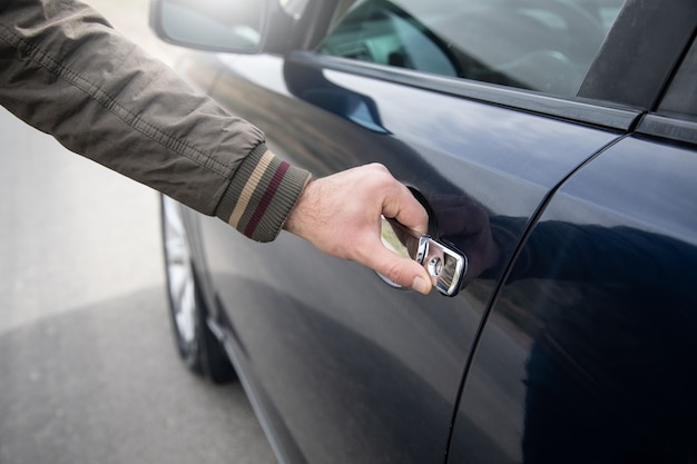 Um homem abre a porta de um carro