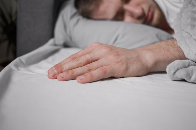 Foto um homem adormecido estende a mão durante o sono