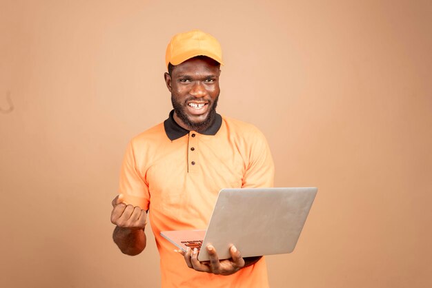 Foto um homem africano entusiasmado, entusiasmado com o que viu no seu portátil.