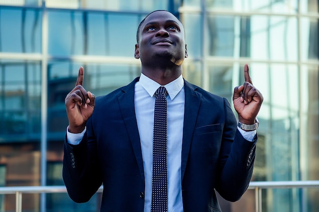 Um homem afro-americano bonito em um terno preto elegante e uma camisa branca, regozijando-se com o sucesso e agradecendo a Deus no contexto dos centros de negócios de vidro das paisagens da cidade um bom conceito