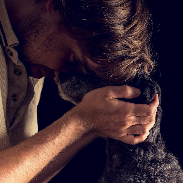 Um homem amoroso a abraçar o seu cão terrier