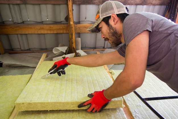 Um homem asiático aquecendo sua casa usando lã mineral