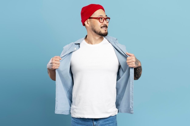 Um homem asiático confiante e elegante hipster usando óculos de chapéu vermelho mostrando camiseta branca