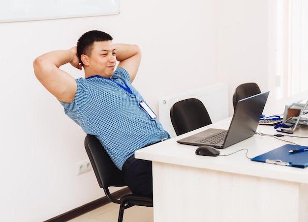 Um homem asiático está trabalhando em um computador, o aluno está estudando o conceito de negócios on-line de dispositivos tecnológicos