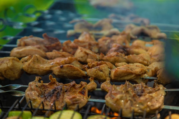 Um homem assa carne em fogo Foco seletivo